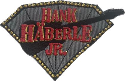 Aufnäher mit dem Schriftzug Hank Häberle jr. auf grauem Grund mit goldener Umrandung